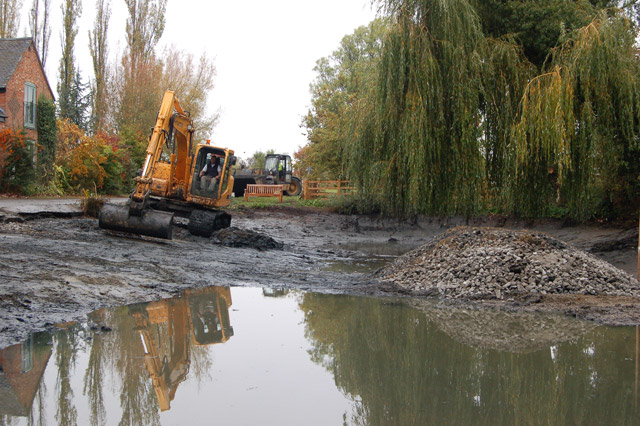 A pond partially drained and dredged to remove accumulated sediment