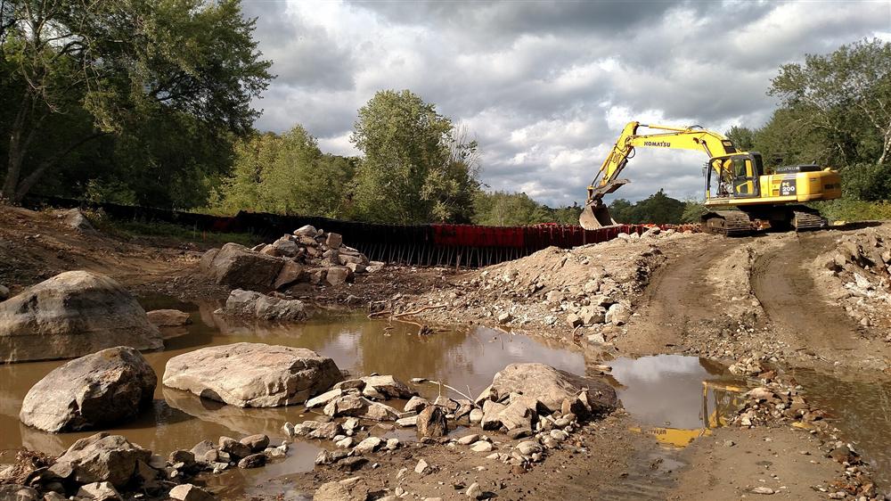 Excavator removing sediment on a coffer dam during a dam removal project